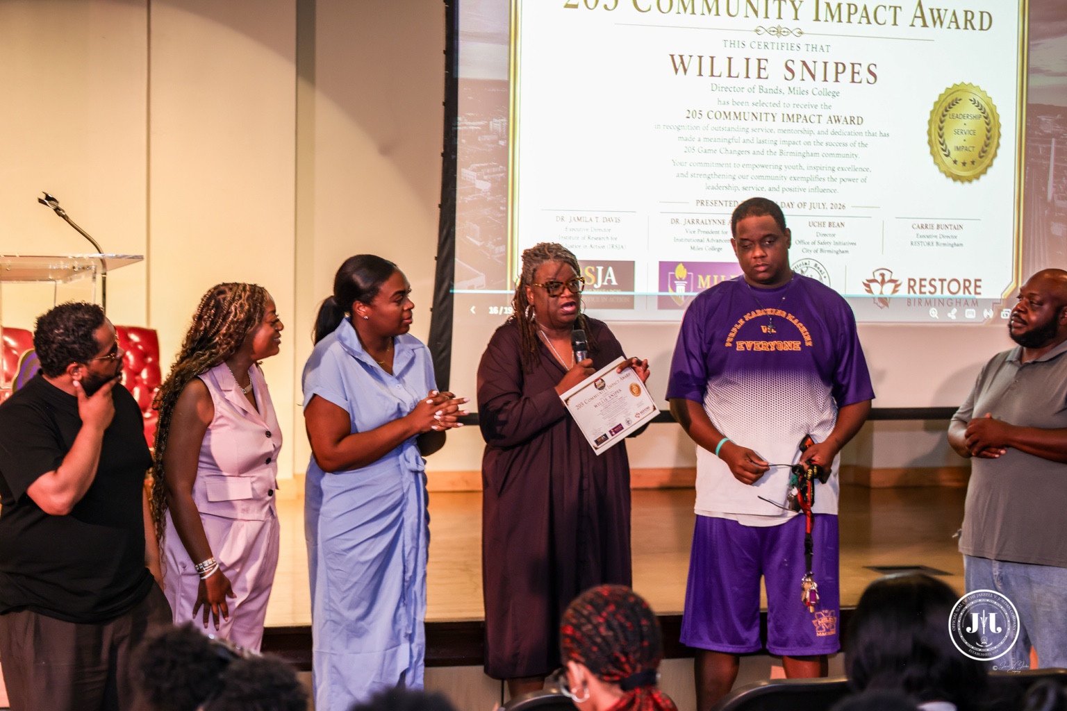 People gathered on a stage during a recognition presentation.