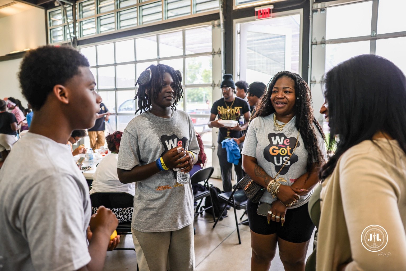 A small group in conversation at an indoor community gathering.
